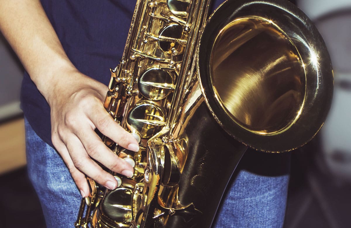 Rechte Hand hält das Saxophon unten und unterstützt den Winkel